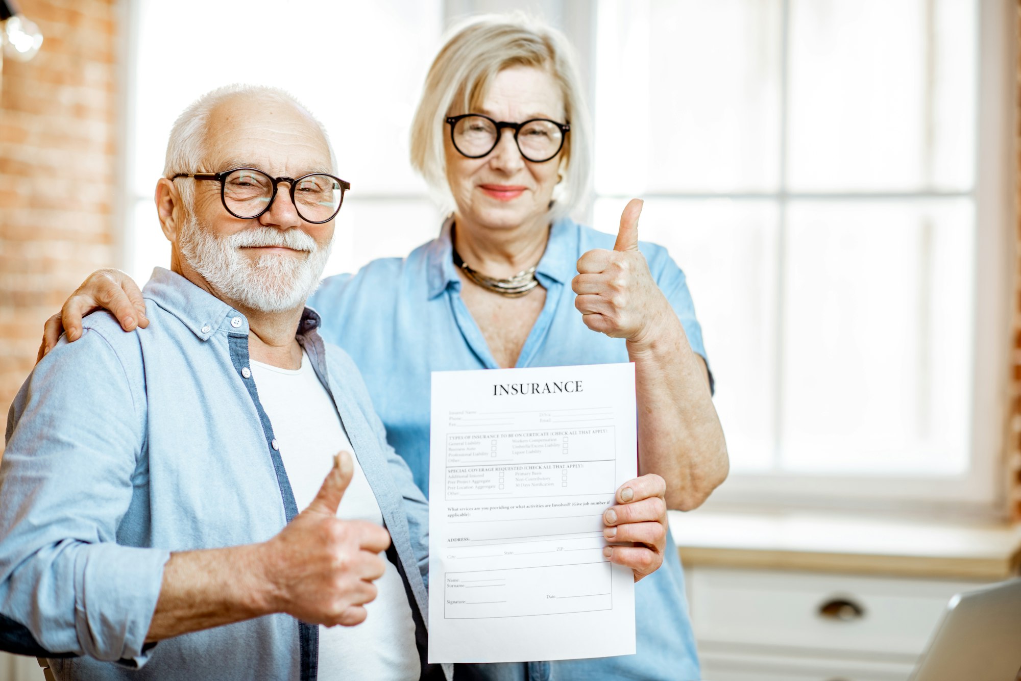 Happy senior couple with insurance document